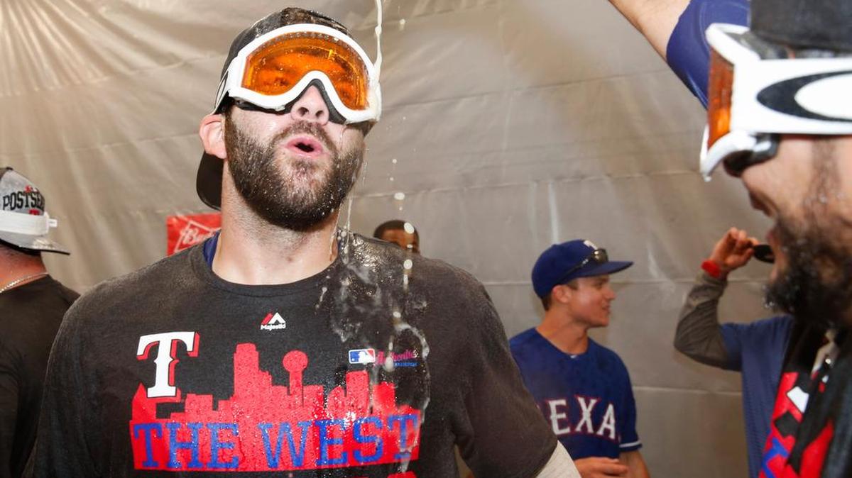 
Texas Rangers’ Mitch Moreland celebrates in the clubhouse Sunday wearing a T-shirt with a faulty design. 
