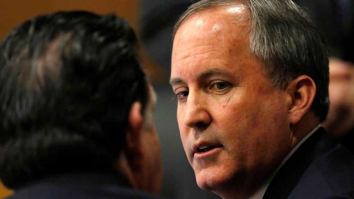 Texas Attorney General Ken Paxton, right, talks with one of his attorneys during a court appearance in December.