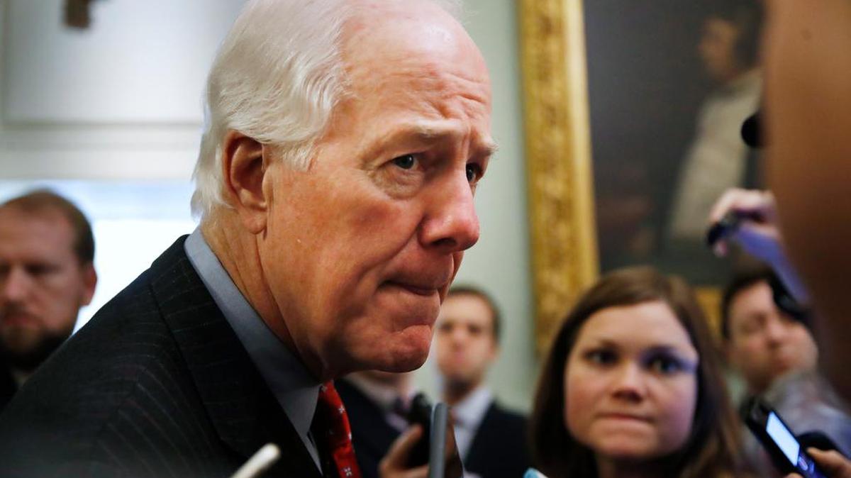 Senate Majority Whip Sen. John Cornyn, R-Texas, listens to a question from a reporter as he leaves the Senate chamber, Friday, Dec. 1, 2017, on Capitol Hill in Washington.