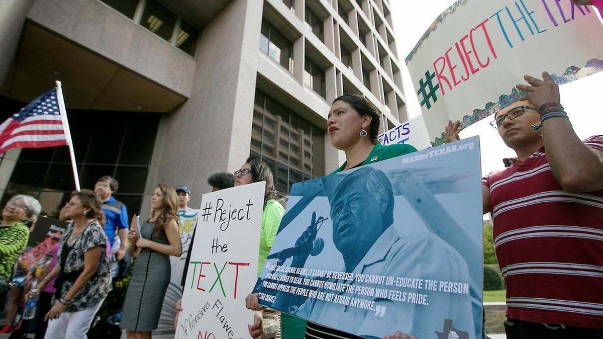 Alonzo Mendez, right, and Montserrat Garibay, second from right, participate in a rally in support of Mexican-Americans outside the board of education building Tuesday, Sept. 13, 2016, in Austin, Texas. Mexican-American advocates and activists gathered for a rally outside the William B. Travis state office building Tuesday morning September 13, 2016 to express their displeasure with the State Board of Education's controversial proposed textbook "Mexican American Heritage", which lists several inaccuracies and false information about Texas' rich cultural heritage. After the rally the board held a public hearing on the topic and others at their regularly scheduled meeting.