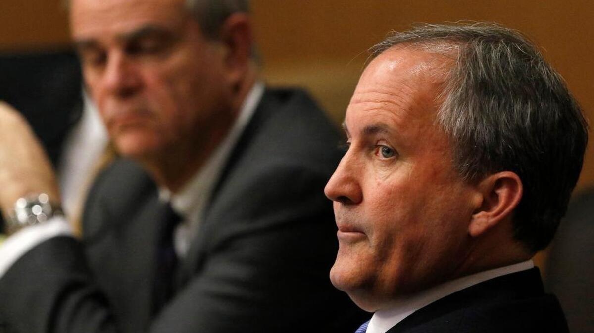 Texas Attorney General Ken Paxton, right, looks at one of the special prosecutors during a pre-trial motion hearing at the Collin County Courthouse on Tuesday, Dec. 1, 2015, in McKinney, Texas.