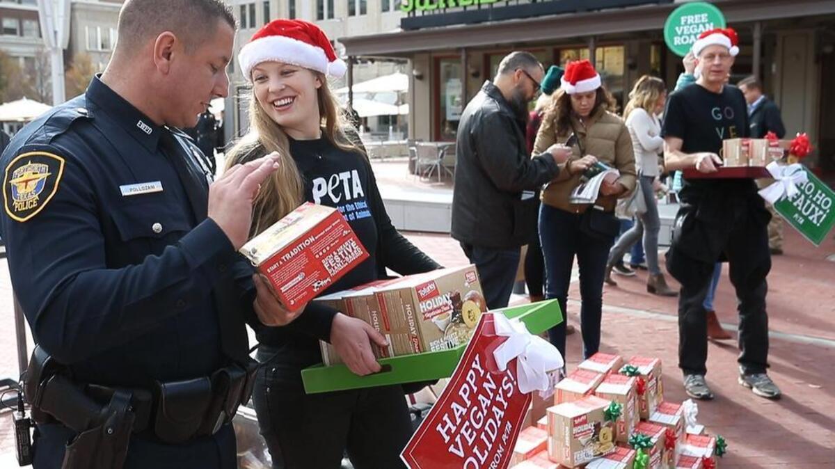 Officer Jimmy Pollozani (left) and PETA's Tricia Lebkvecher (right, cq) handing out Tofurkys. The Fort Worth Police Department, along with PETA and the vegan restaurant, Spiral Diner, gave away free Tofurkys (tofu turkeys) and vegan deserts to people in Sundance Square in 2016.