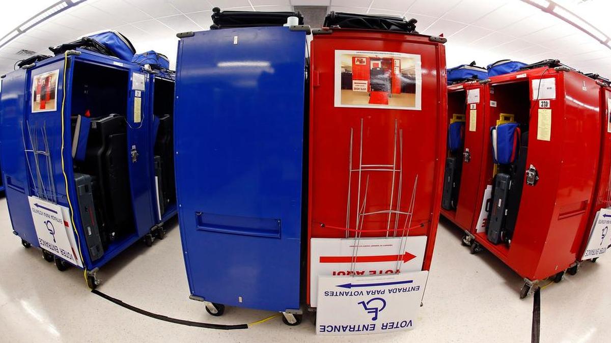 Hundreds of EEC (Election Equipment Carrier) voting machines, colored red and blue, ready to be distributed to polling places.