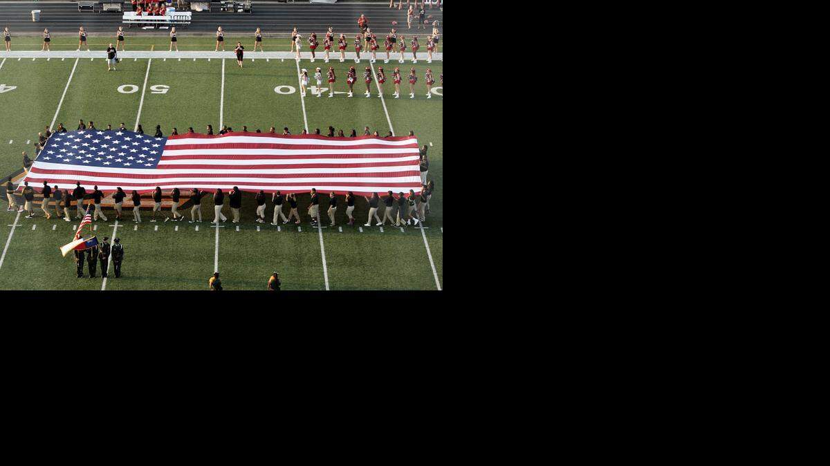
The American Flag is brought onto the field for opening ceremonies of Arlington Martin/DeSoto high school football game last year. 
