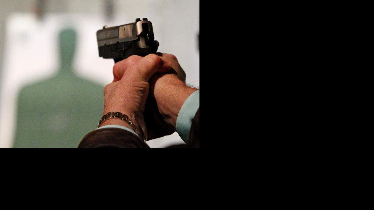 
A class member fires at a target during a class for a concealed handgun license. 
