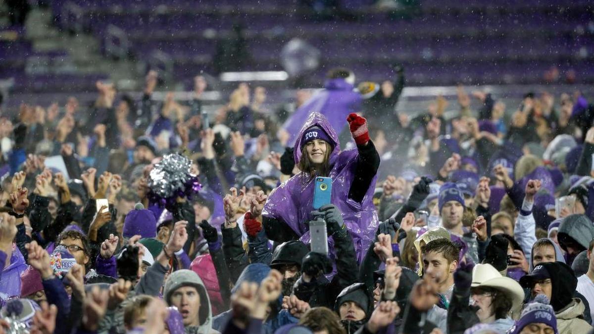TCU fans celebrate after rushing the field following their 28-21 double-overtime win against Baylor in an NCAA college football game.