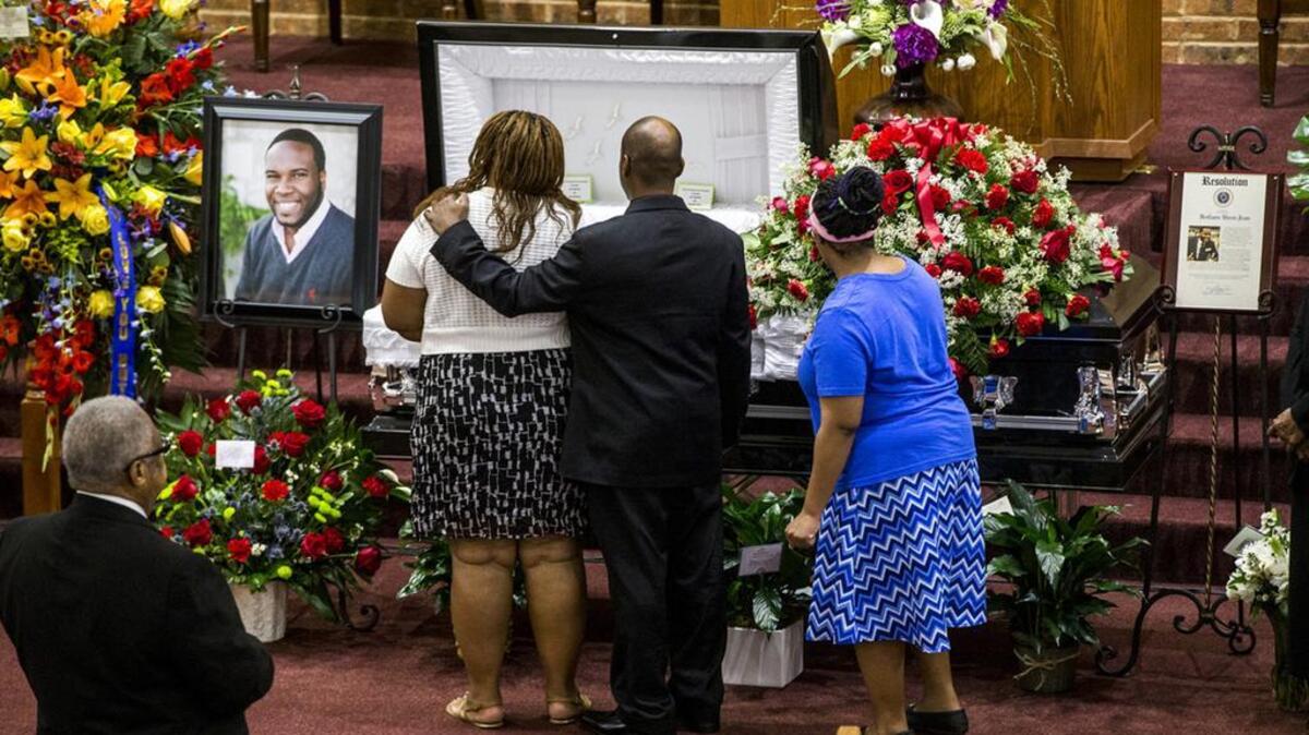 In this Sept. 13, 2018, file photo, mourners console one another during the public viewing before the funeral of Botham Shem Jean at the Greenville Avenue Church of Christ in Richardson, Texas.