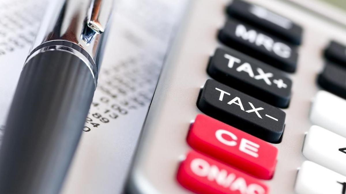 Calculating numbers for income tax return with pen and calculator