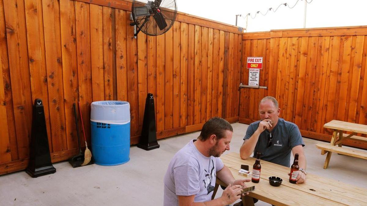 David Andrews, of Norwich England and Tony Galer of Halesworth, England take a smoke break at Billy Bob's Texas smoking patio. The club will prohibit smoking in May, Wednesday, April 27, 2016.