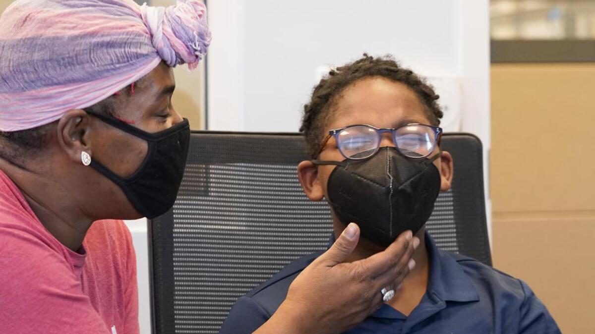 Latosha Wilson, left, comforts her son Kerington Wilson, 9, after he received a COVID-19 vaccination in Fort Worth.