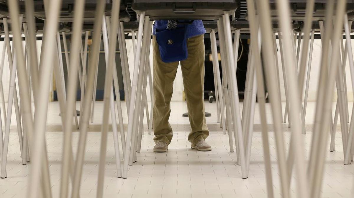 A man fills out a ballot while standing at a voting booth at City Hall in San Francisco, Tuesday, June 7, 2016. Voter turnout is expected to be higher then normal in the nation's most populous state for Tuesday's presidential primary.