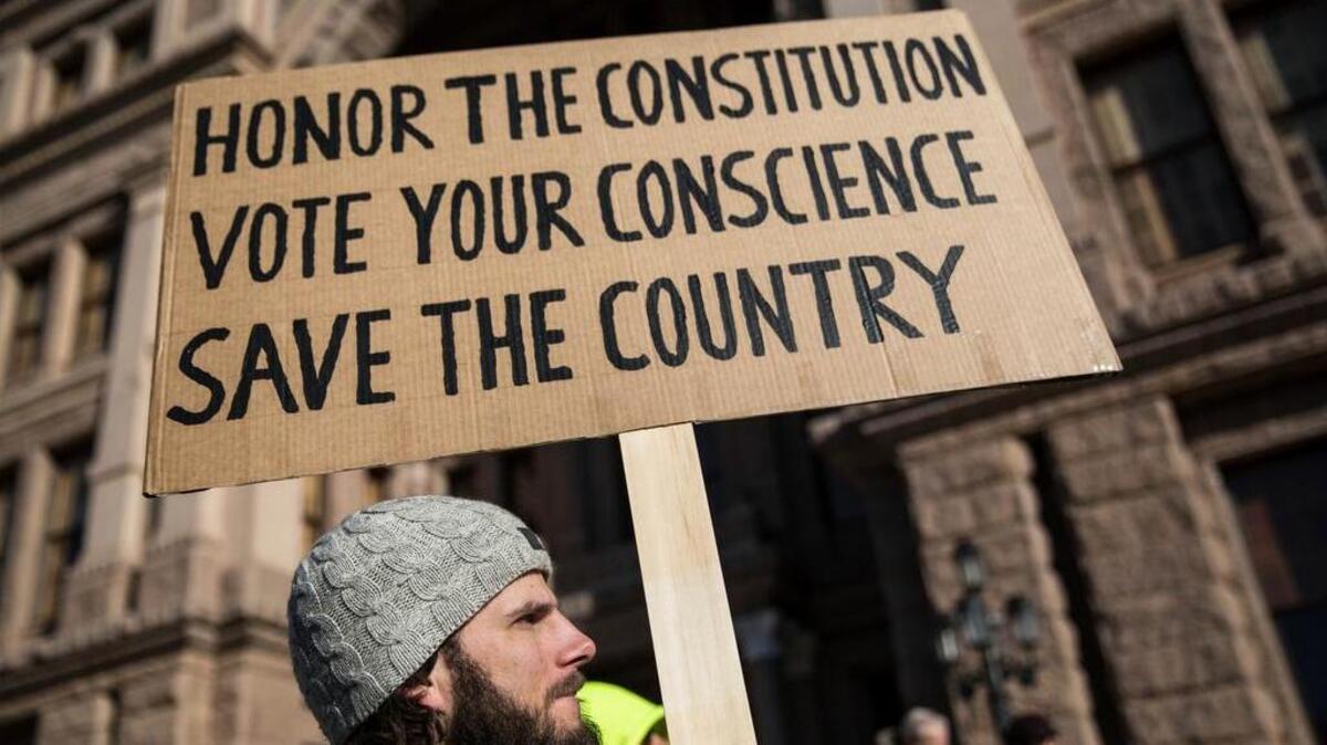 Hannes Mandel and a group of demonstrators gather outside of the Texas State Capitol in an attempt to influence the 38 Republican electors from across the state to not vote for Donald Trump when they cast their formal ballots in Austin, Texas on Monday.