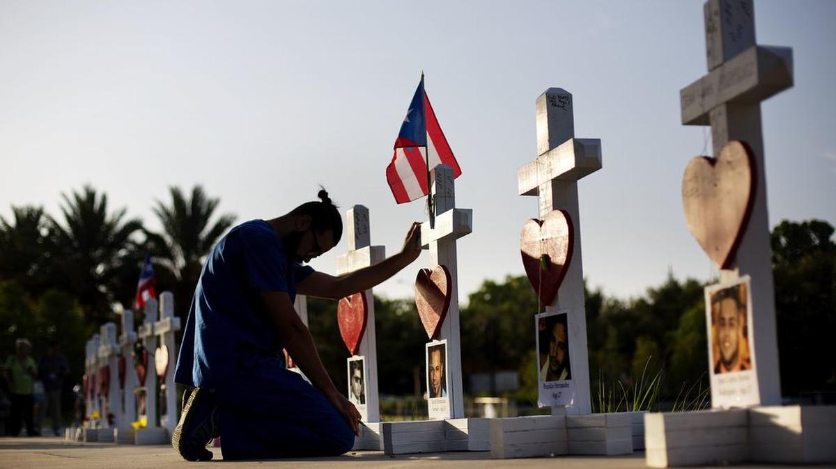 Ernesto Vergne prays at a cross honoring his friend Xavier Emmanuel Serrano Rosado.