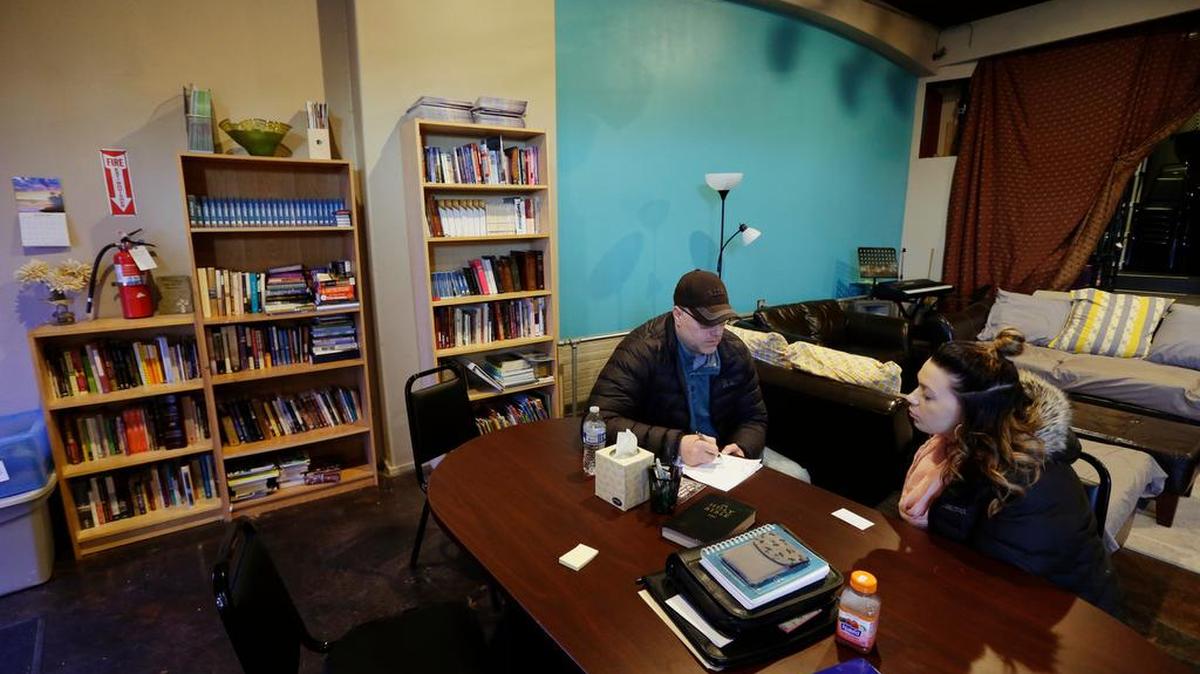 In this photo taken Feb. 27, 2017, Jessica Wolfe, right, talks about her life story as she sits at The Genesis Project, a drop-in center for victims of sex trafficking in SeaTac, Wash. with King County Sheriff's Deputy Andy Conner, left, who founded center. Wolfe, who was forced into sex trafficking shortly after her 19th birthday is now struggling to find housing and a job after background checks find her prostitution convictions, but a measure passed last week in the Washington state Senate could rewrite current law to make it easier for victims of trafficking to vacate prostitution convictions.