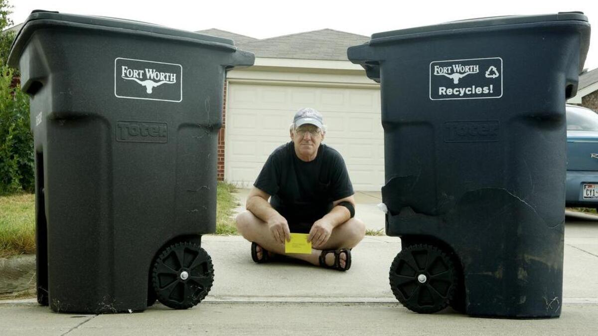 Robert Damora holds a warrant for his arrest after failing to properly discard trash and recycling at his home in north Fort Worth, Texas Thursday August 18, 2016.