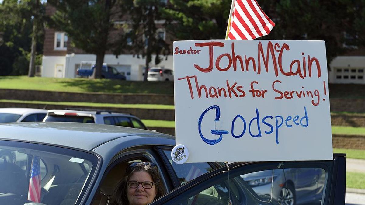 Debbie Rasmussen of Arnold, Md., sits in her car as she watches for any activity with the funeral and burial for Sen. John McCain at the United States Naval Academy in Annapolis, Md., Sunday, Sept. 2, 2018.