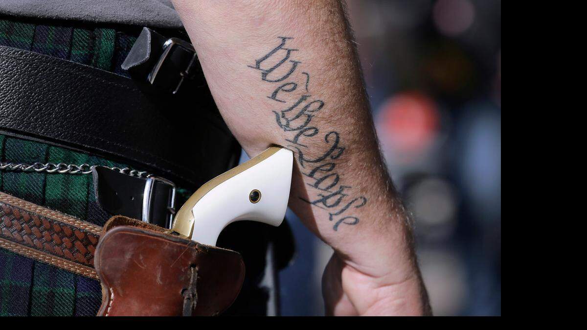 
Scott Smith, a supporter of open carry gun laws, wears a pistol as he prepares for a January rally at the Capitol in Austin. 
