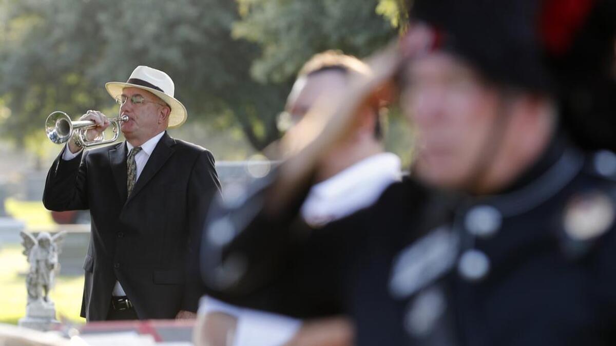 Bugler Kyle Hantz plays retreat to close out the 90th annual Memorial Day service at Mount Olivet Cemetery in Fort Worth on Monday.