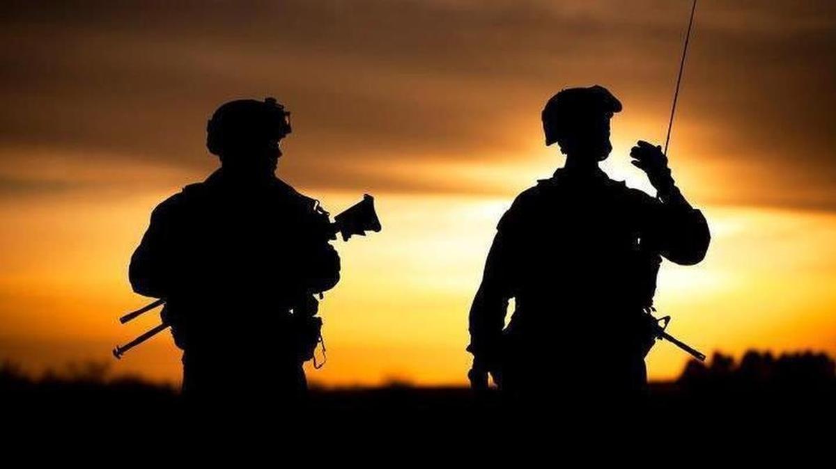 U.S. soldiers are shown in Afghanistan as the sun sets behind them.