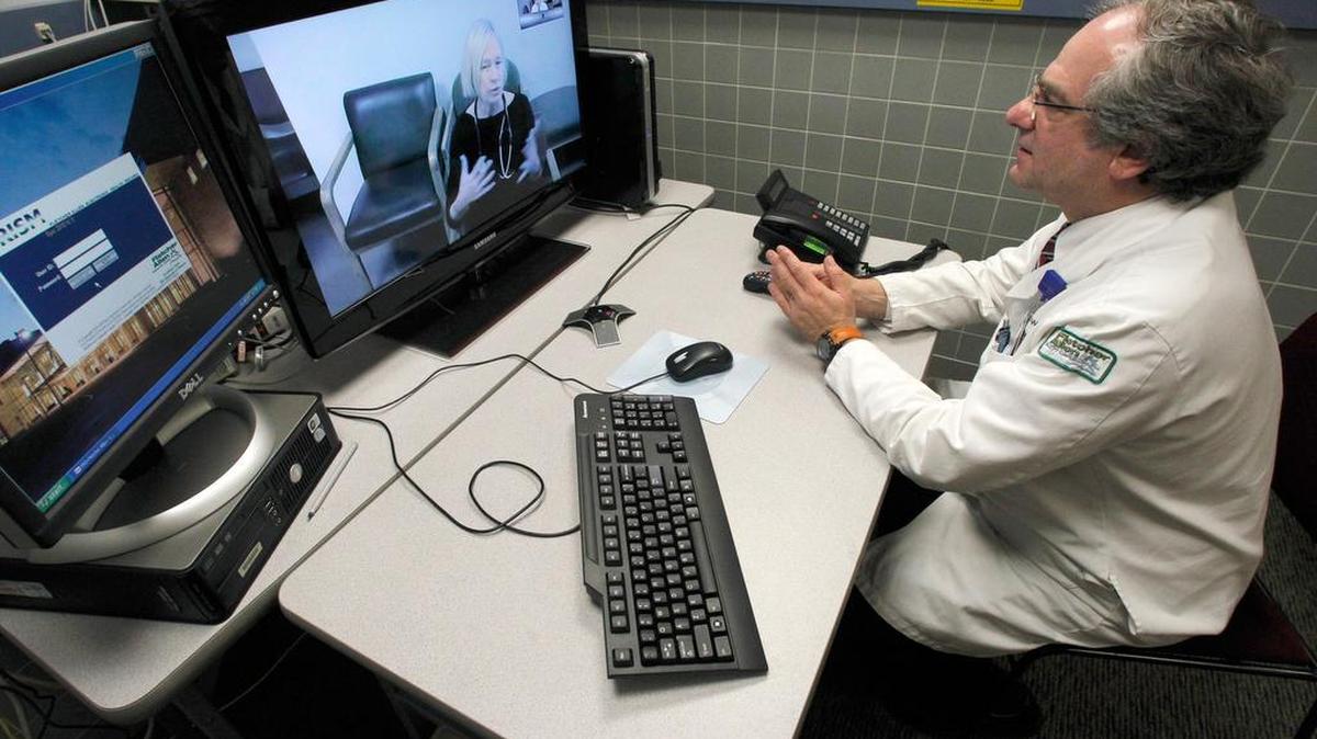 Dr. Terry Rabinowitz, right, talks with nurse Leslie Orelup at Helen Porter Nursing Home in Burlington, Vt. Doctors have used video feeds and other technology for years to treat patients in remote locations. But experts say growing smartphone use and customer demand are fueling a rapid expansion of telemedicine into everyday care the family doctor used to handle.
