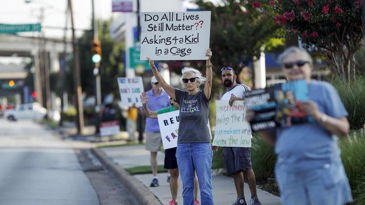 Cathy Clark, center, stands with fellow activists protesting the policy of separating immigrant children from their parents detained at the southern border on Friday, June 28, 2019, on University Drive in Fort Worth.