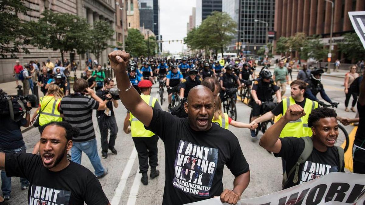 Black Lives Matter demonstrators carry signs and yell as they march in downtown Cleveland Monday.
