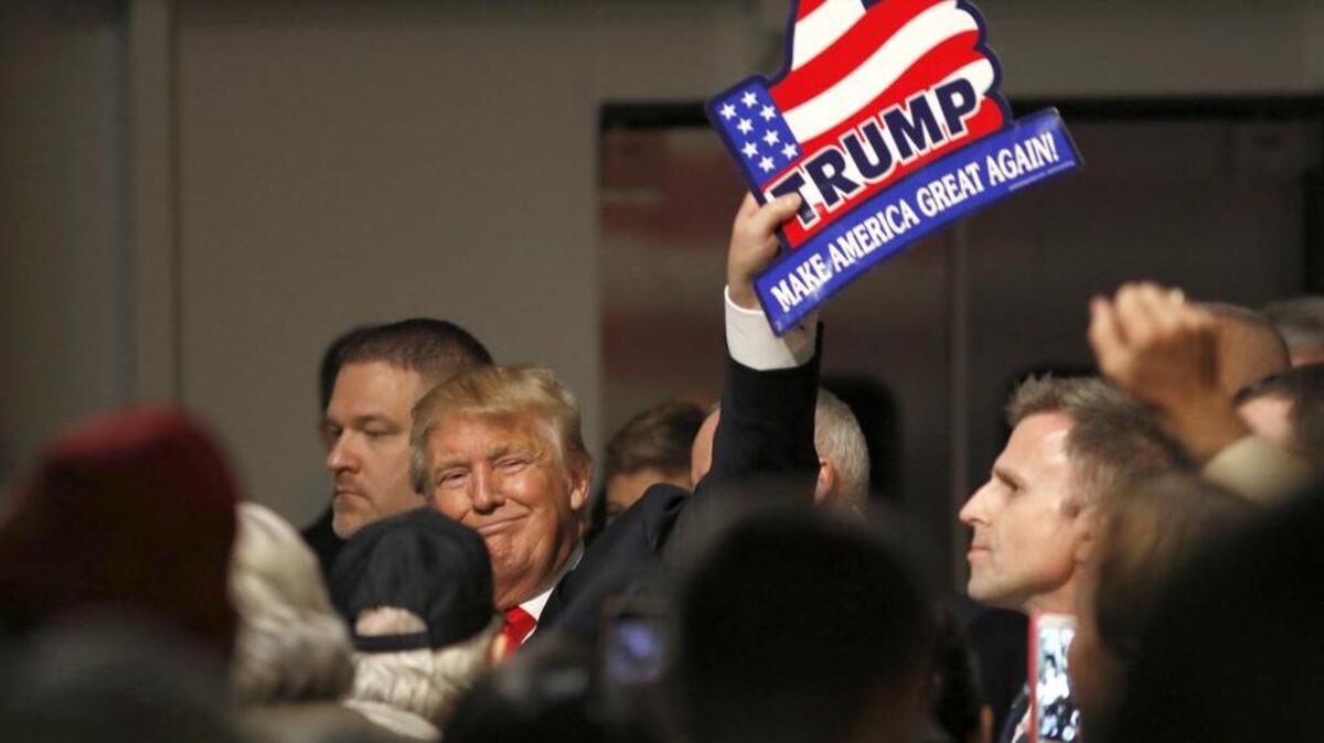 Republican presidential candidate, businessman Donald Trump, holds one of his signs after a rally coinciding with Pearl Harbor Day at Patriots Point aboard the aircraft carrier USS Yorktown in Mt. Pleasant, S.C., Monday, Dec. 7, 2015.