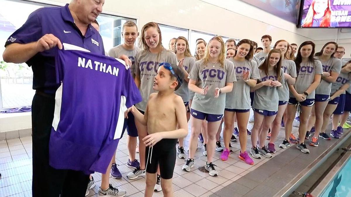 TCU’s Richard Sybesma recently retired after 38 years as swim coach. In this photo from 2016, 8-year-old Nathan Lin was given a personalized shirt from the coach as part of the Make a Wish effort. Nathan later died from brain cancer.