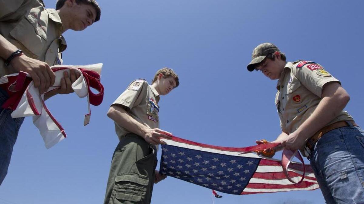 Bridger Planz, with help from Corey Estes, right, and Ryan Hussey, left, of Troop 321 in North Richland Hills, is completing his Eagle Scout Project for the Boy Scouts of America on Wednesday, June 13, 2012. He is performing a mass American Flag retirement of 600 flags for American Legion Post 655 in Haltom City. They are cutting up a flag in preparation for burning it.