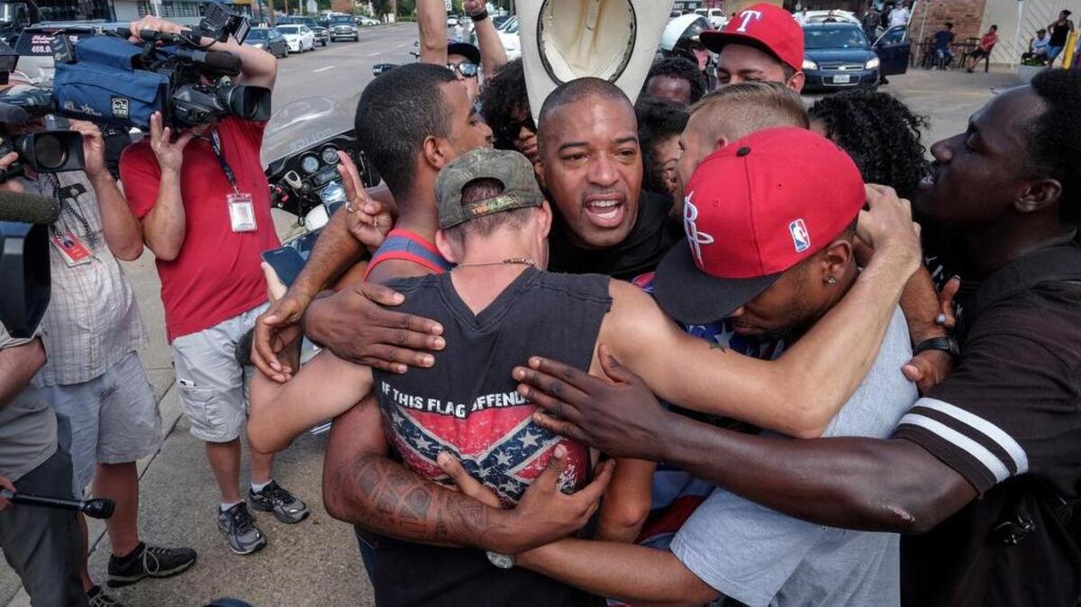 Ty Hardaway, 44, of Dallas is in the center of a group hug after some marchers from Black Lives Matter had a meeting with counterprotest group supporting Blue Lives Matter. The two groups stood on separate sides of a busy intersection and ultimately came to an understanding.