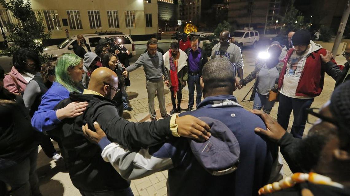 Participants link arms in prayer during a protest at City Hall over the discipline announced for officer William Martin whose arrest of Jacqueline Craig and her daughter was caught on video that went viral on social media, Monday, January 9, 2017.
