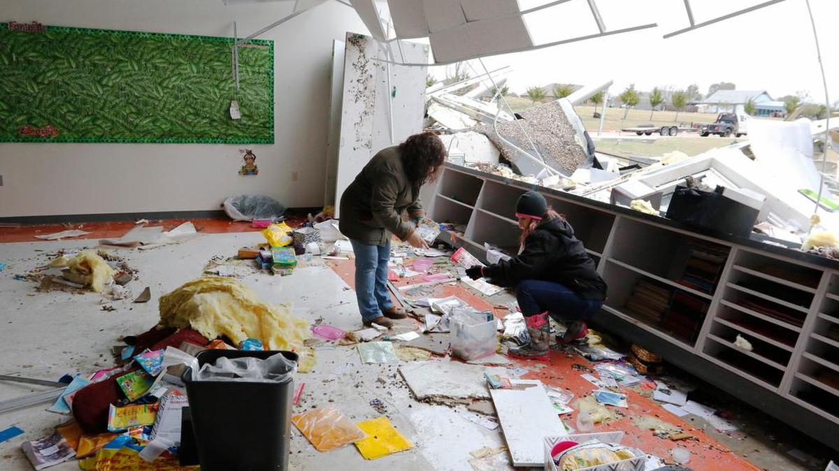 Viana Armstrong, left, and Christina Lediaev try to salvage school materials at the storm-damaged Donald T. Shields Elementary School in Glenn Heights, Texas, on Monday, Dec. 28, 2015.