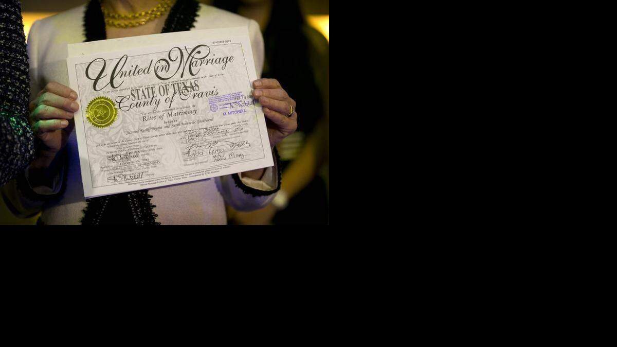 
Suzanne Bryant shows her marriage license at Highland Lounge in Austin after she and her partner, Sarah Goodfriend, became the first legally married gay couple in Texas.
