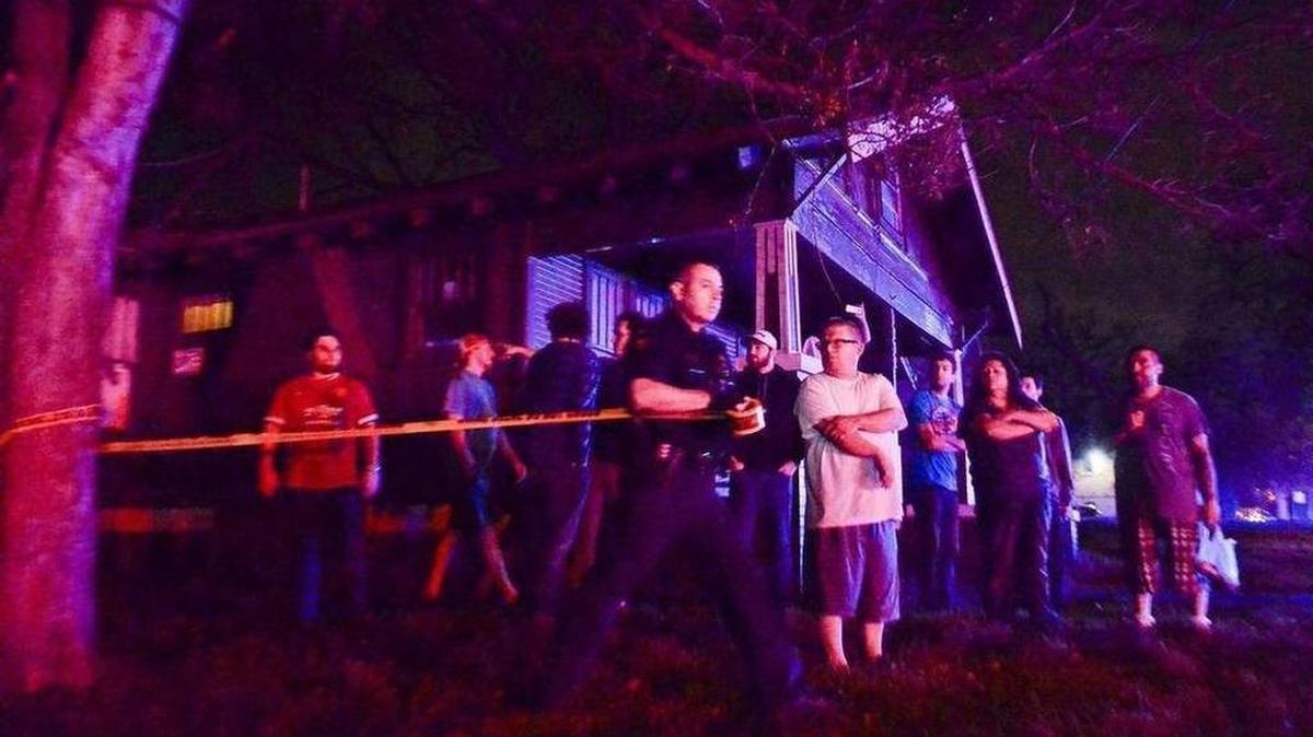 Police officer Ryan Kane stretches perimeter tape across the shooting scene in Denton.