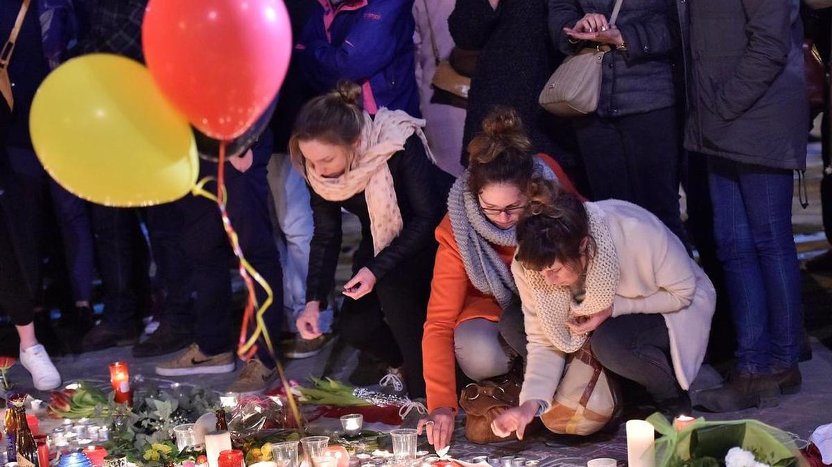 People bring flowers and candles to Place de la Bourse, Brussels, to mourn for the victims on Wednesday evening, March 23, 2016. Bombs exploded Tuesday at the Brussels airport and one of the city's metro stations, killing and wounding scores of people, as a European capital was again locked down amid heightened security threats.