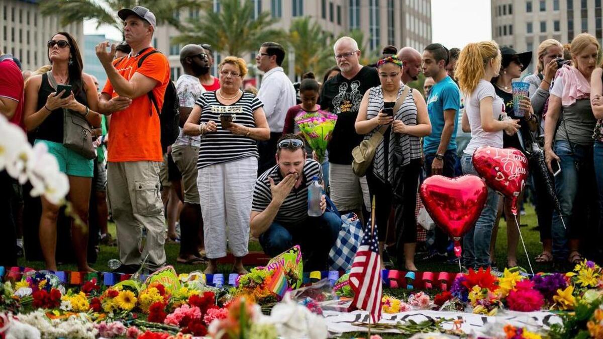 Mourners gather outside the Dr. Phillips Center for the Performing Arts, where a vigil for the victims of the Pulse nightclub shooting is planned, in Orlando, Fla., June 13, 2016. A gunman who pledged allegiance to the Islamic State killed 49 people and wounded 53 in the crowded gay nightclub in Orlando early Sunday.
