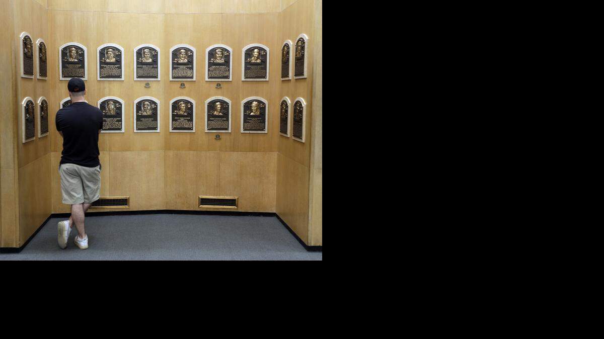 
A fan looks at player plaques at the Baseball Hall of Fame in Cooperstown, N.Y. 
