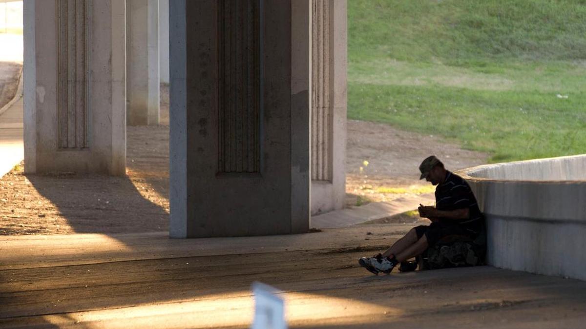 A homeless man rests Tuesday on East Lancaster Avenue in Fort Worth.