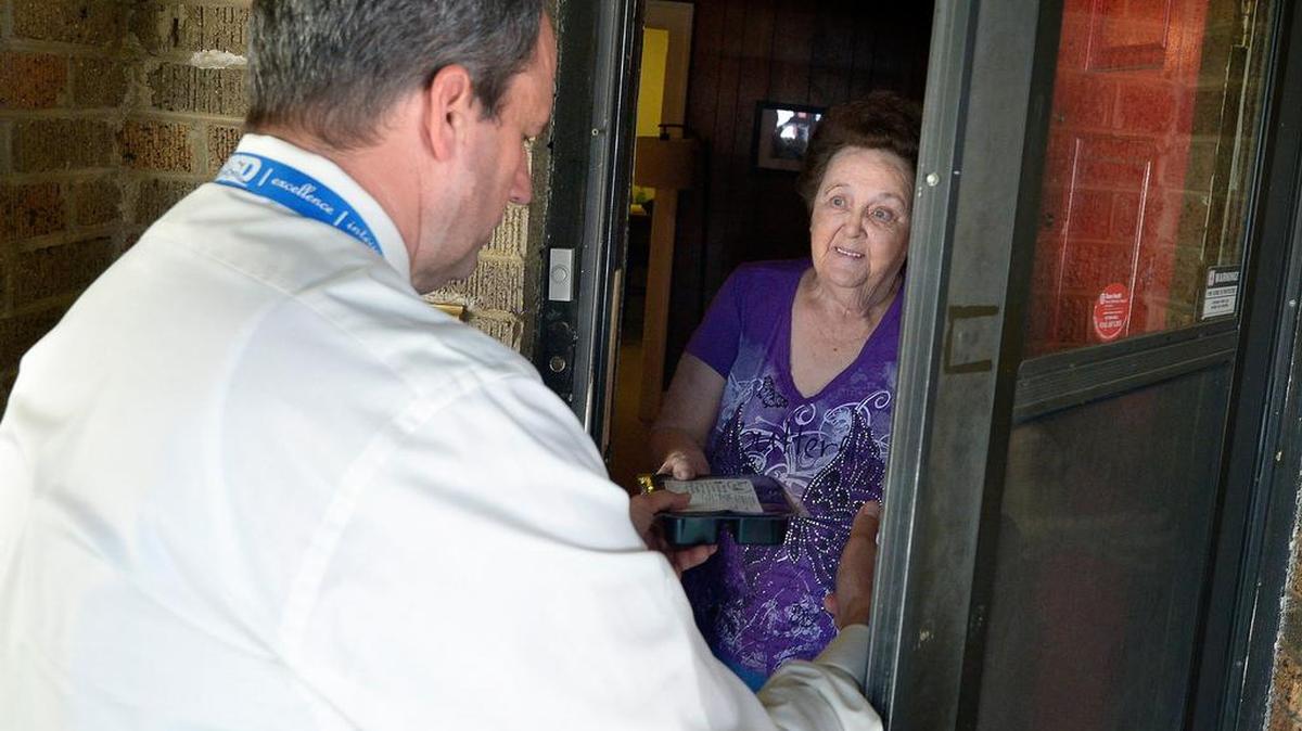Meals on Wheels volunteer Rick Tice makes a delivery Monday to Shirley E. on his route in Fort Worth.