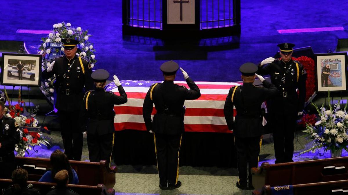 Law enforcement officers salute the casket of Dallas Police Sr. Cpl. Lorne Ahrens during his funeral service at Prestonwood Baptist Church in Plano, Texas, Wednesday, July 13, 2016. Ahrens and four other officers were slain by a sniper during a protest last week in downtown Dallas.