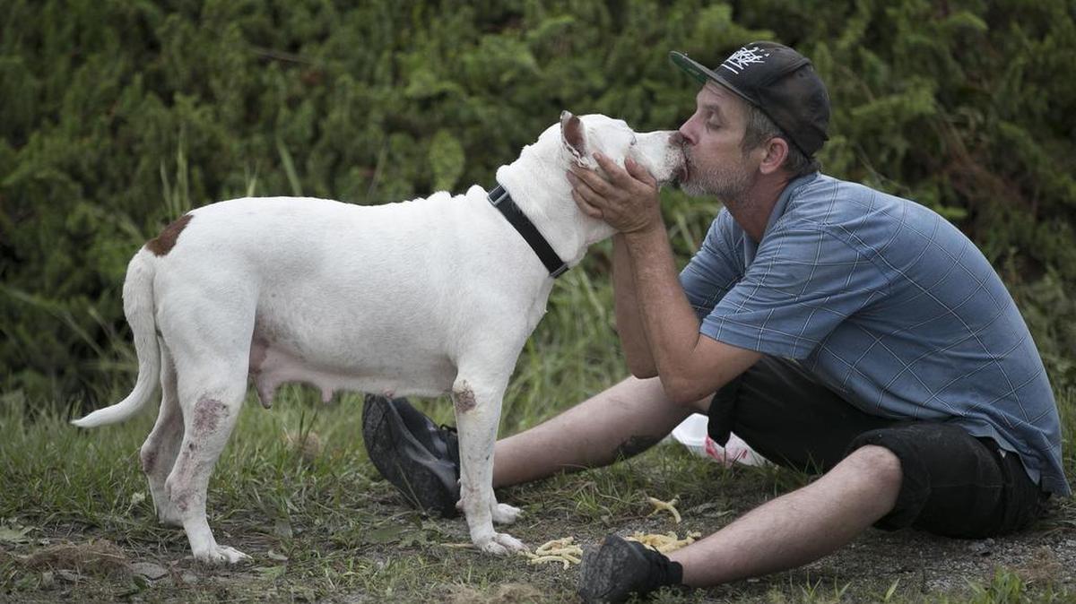 Jody Jones kisses his pit bull Emma in Newport, North Carolina, in this 2018 file photo.