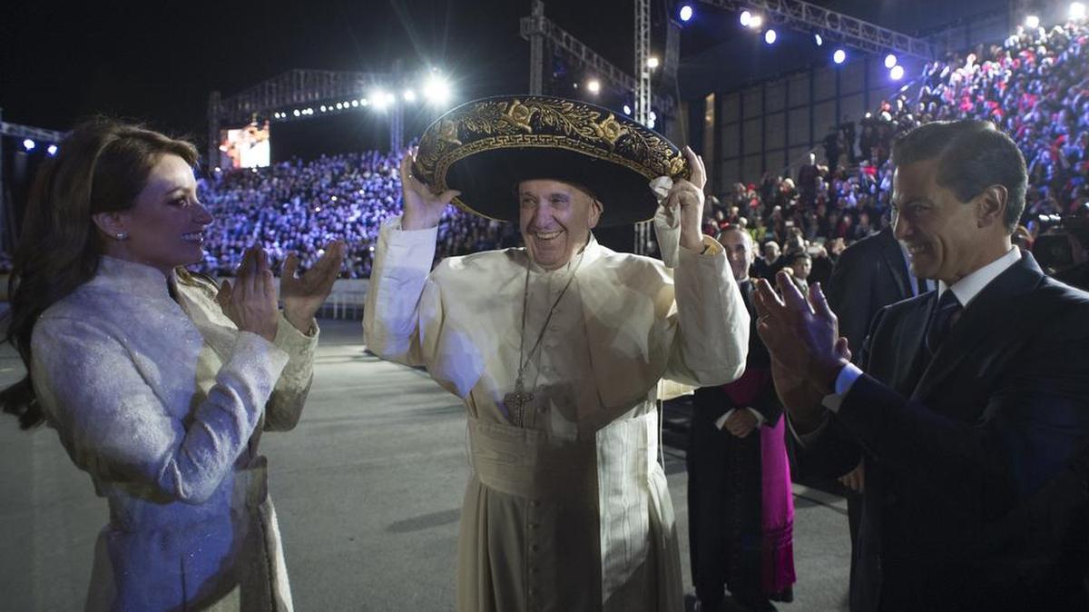 Pope Francis wears a traditional Mexican sombrero hat as Mexico's President Enrique Pena Nieto, right, and first lady Angelica Rivera applaud, upon his arrival to the Benito Juarez International Airport in Mexico City Friday. The pontiff is in Mexico for a week-long visit.