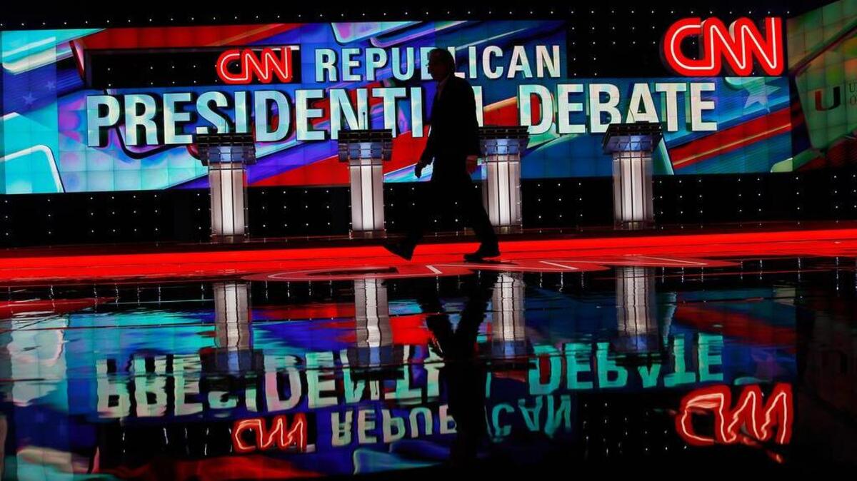 A CNN staffer walks across the stage where the Republican presidential debate sponsored by CNN, Salem Media Group and the Washington Times will take place, at the University of Miami, Thursday, March 10, 2016, in Coral Gables, Fla.