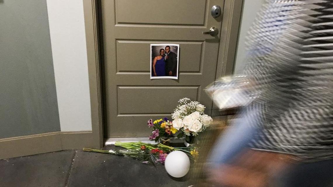 A resident passes flowers at the front door of Botham Shem Jean, who Dallas police say was shot Thursday by Amber Guyger, an off-duty police officer who mistakenly thought her apartment was his, as photographed on Monday, Sept. 10, 2018 at the South Side Flats in Dallas, Texas. Guyger was in uniform.