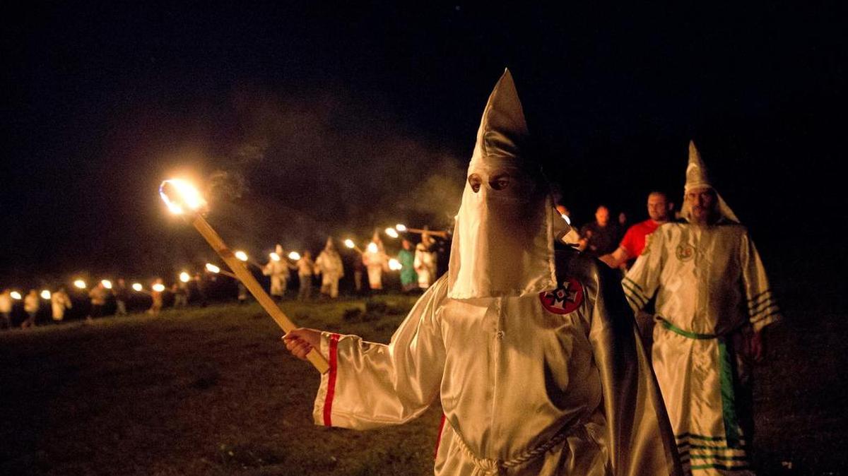 In this Saturday, April 23, 2016 photo, members of the Ku Klux Klan participate in cross burnings after a "white pride" rally in rural Paulding County near Cedar Town, Ga. Born in the ashes of the smoldering South after the Civil War, the KKK died and was reborn before losing the fight against civil rights in the 1960s. Membership dwindled, a unified group fractured, and one-time members went to prison for a string of murderous attacks against blacks. Many assumed the group was dead, a white-robed ghost of hate and violence.