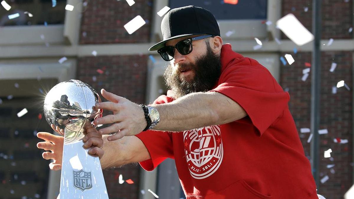 New England Patriots’ Julian Edelman reaches for a Super Bowl trophy during their victory parade through downtown Boston, Tuesday, Feb. 5, 2019.
