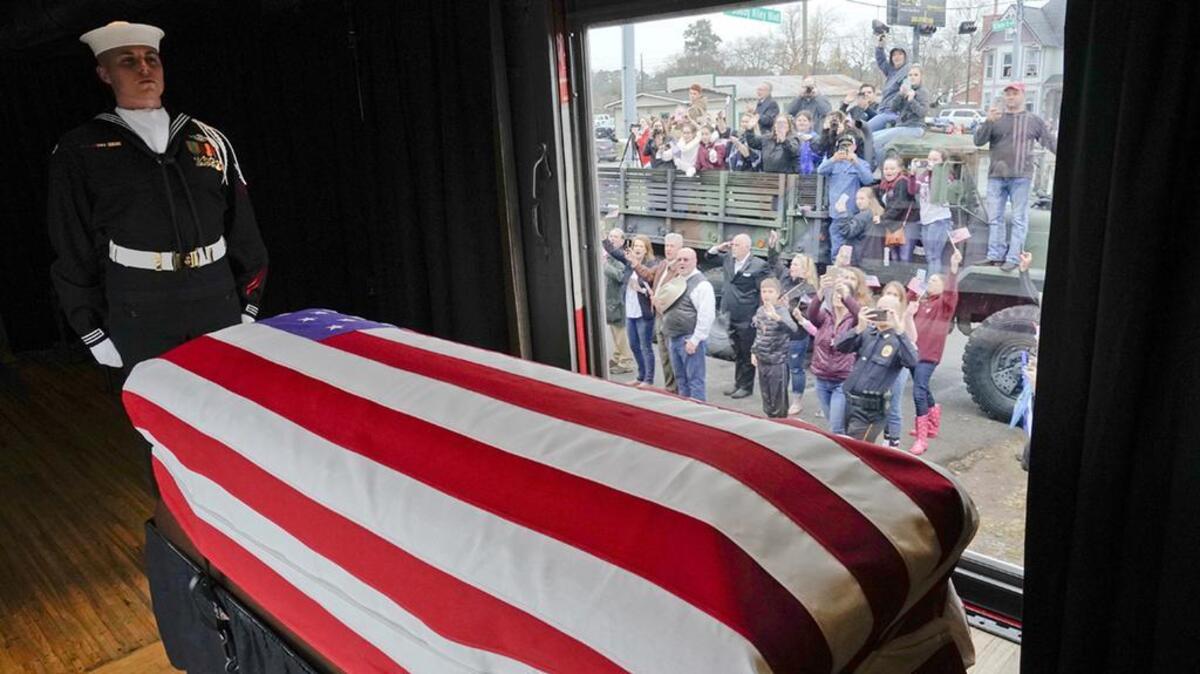 The flag-draped casket of former President George H.W. Bush passes through Magnolia, Texas, Thursday, Dec. 6, 2018, along the route from Spring to College Station, Texas.