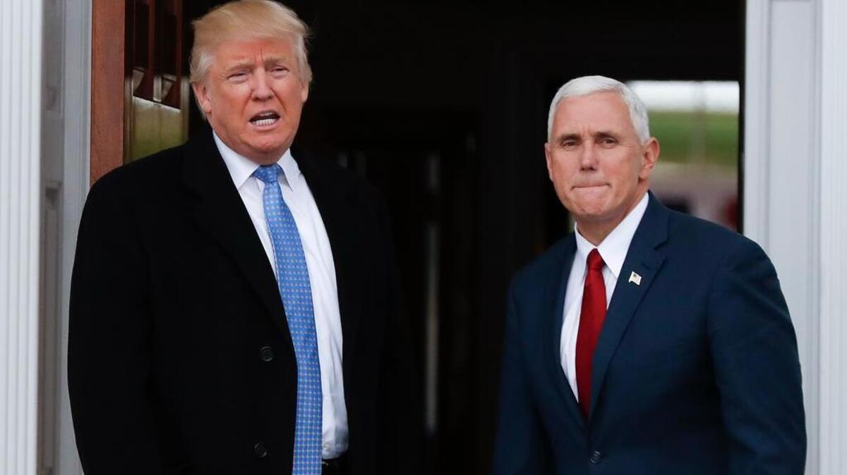 President-elect Donald Trump, left, talks to media Sunday as he and Vice President-elect Mike Pence arrive at the Trump National Golf Club Bedminster clubhouse in New Jersey.