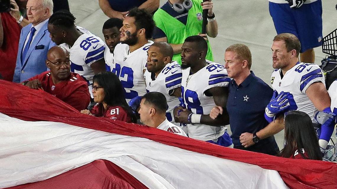 Dallas Cowboys owner Jerry Jones stand with players and head coach for the national anthem last month.