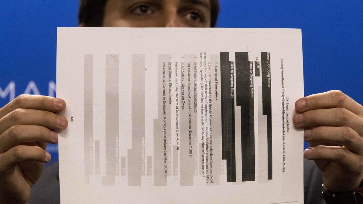 An aide to U.S. Rep. Jerrold Nadler, chair of the House Judiciary Committee, holds a page from the redacted Robert Mueller report during a light and mic test ahead of a news conference on April 18, 2019.